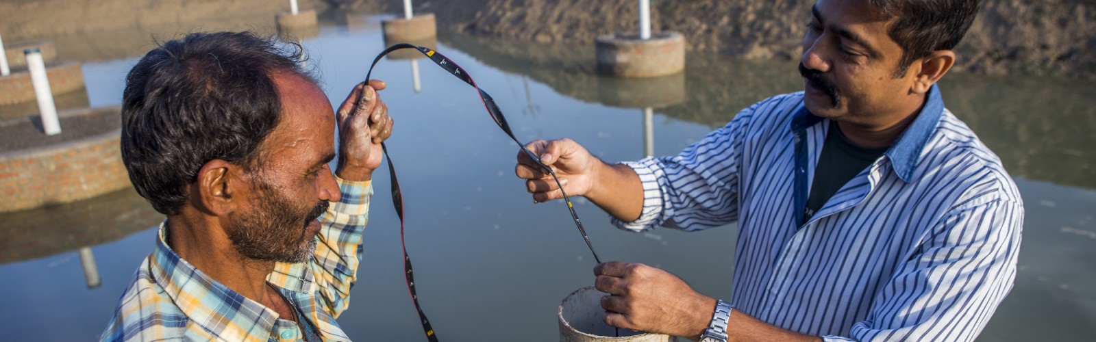  A scientist measuring the water collected from a pond created under the Underground Taming of Floods for irrigation