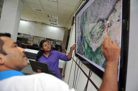 GIS staff discuss a satellite map.