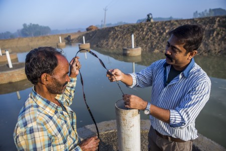  A scientist measuring the water collected from a pond created under the Underground Taming of Floods for irrigation