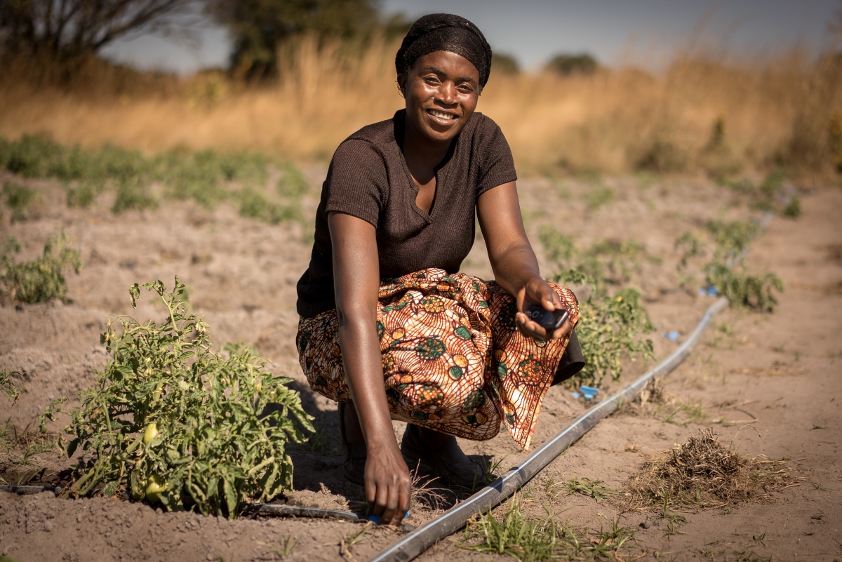 A woman in Kenya's Central Region with a solar irrigation pump she uses on her farm.