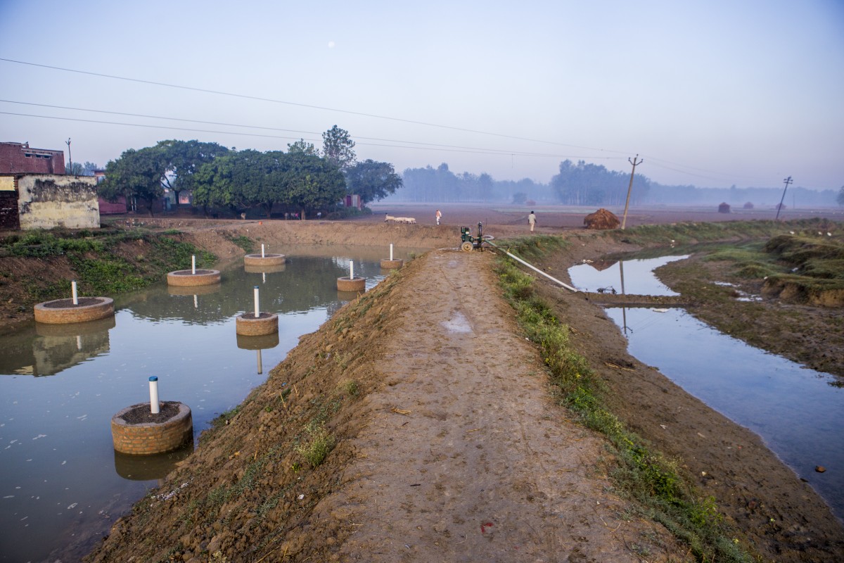 A view of a stream and water collected pond created under the Underground Taming of Floods for irrigation (UTFI)